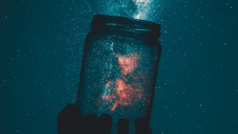 silhouette of person holding glass mason jar