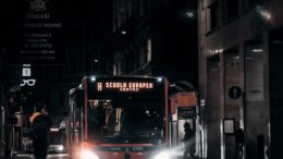 public bus driving along night street