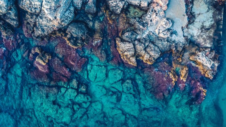 aerial photography of rocks beside body of water