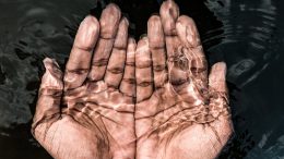 crop man with hands under transparent water